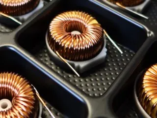 Copper-wound toroidal transformers arranged in a packaging tray
