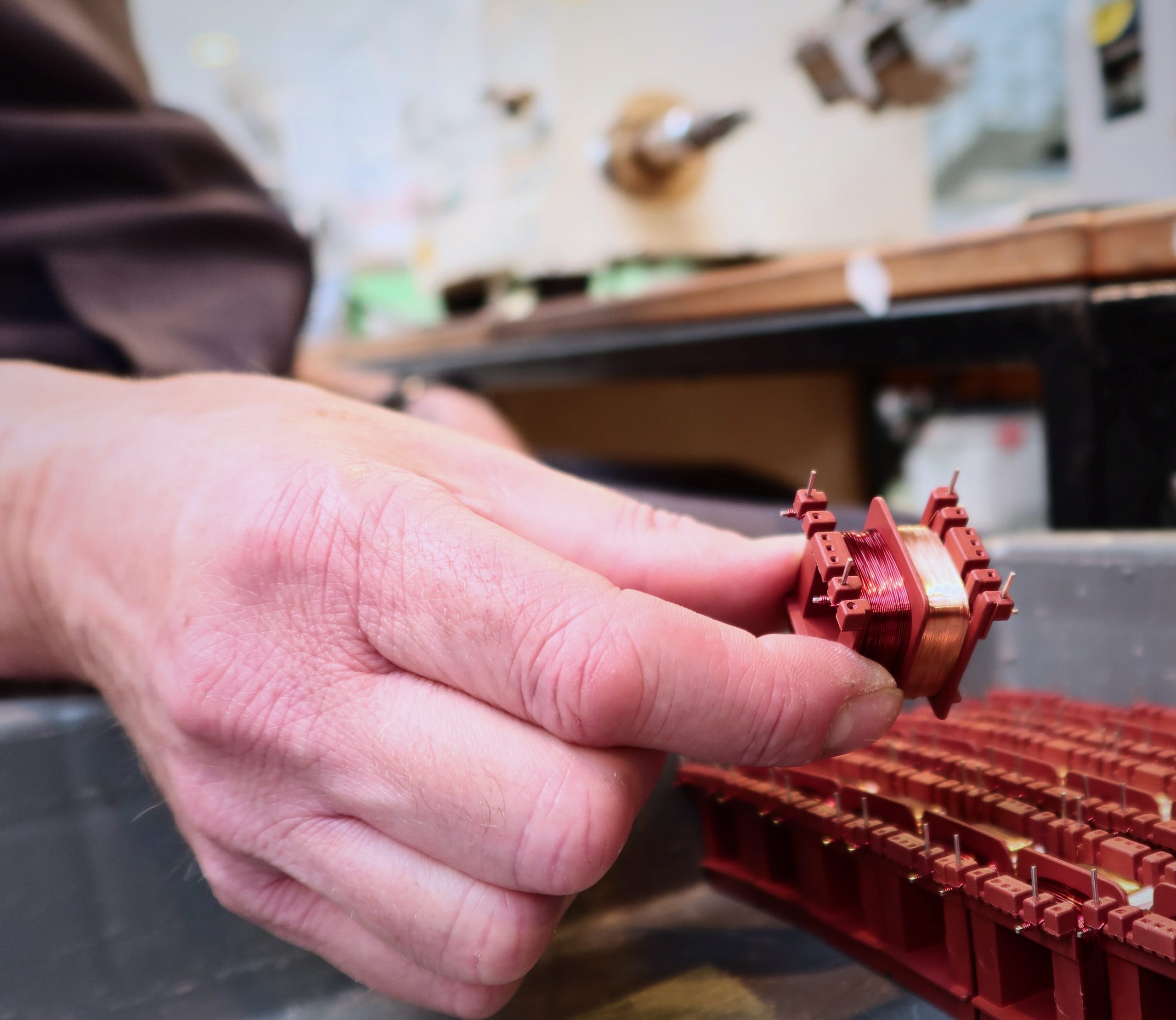 hand assembling wound transformer component with copper coil for bespoke electrical applications